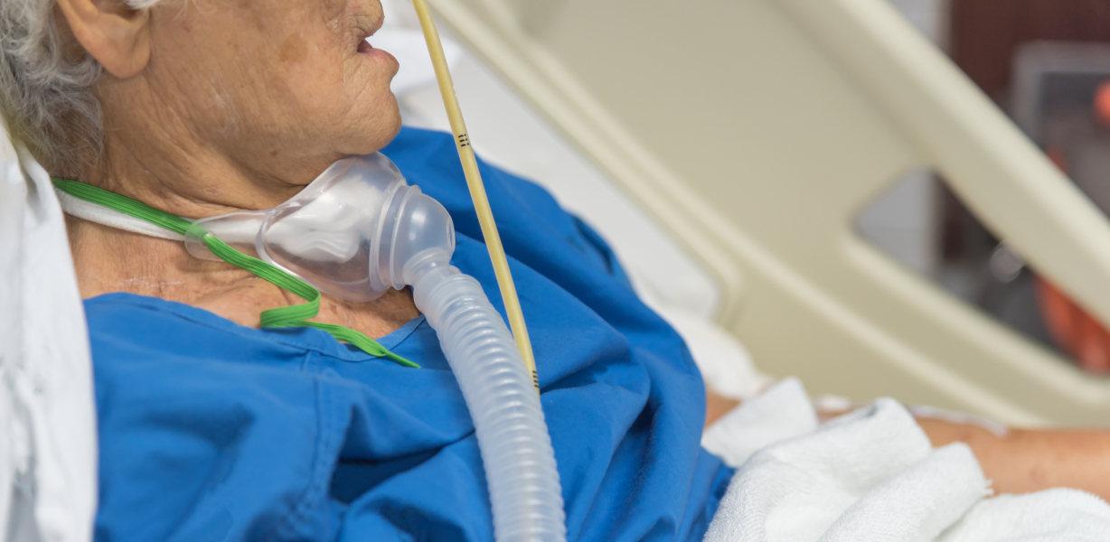 An elderly patient receiving ventilator support via tracheostomy