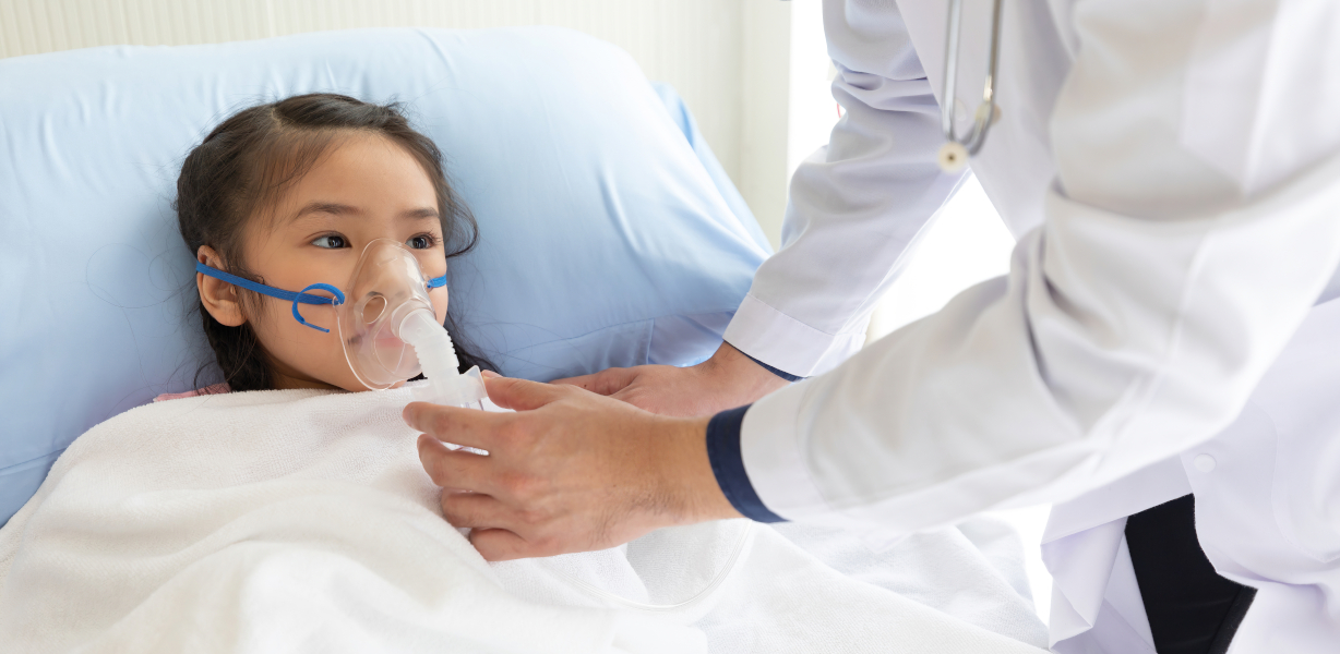 Young girl on a ventilator in a hospital bed A young girl using a ventilator while in a hospital bed